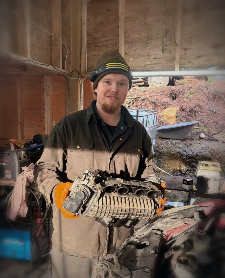 Tyler Muryn in his shop holding a supercharger